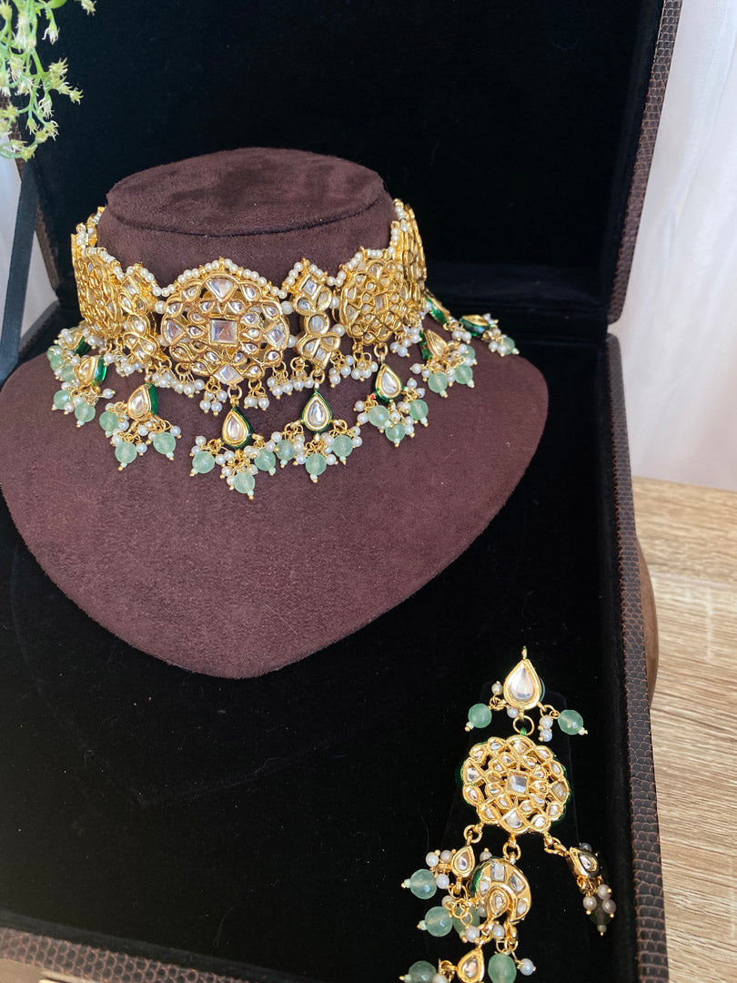 Hemali Kundan Choker set is gold plated, with white stones, and various color Beads. It has choker and earrings. If you want any specific color other than mention above, please contact us on whatsapp at +1 (313)-727-1045