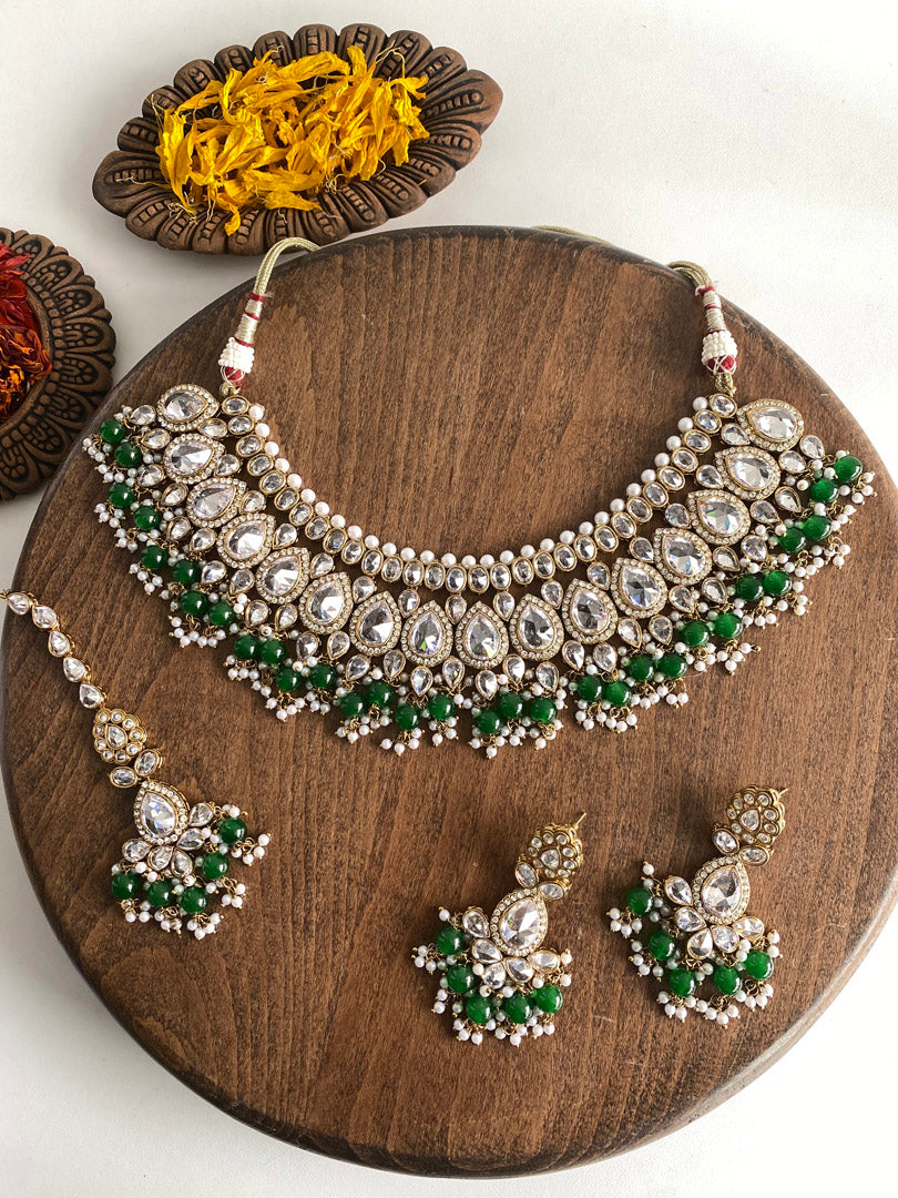 Festive Essentials - Our most loved set, Nilu, perfect for modern and traditional look. It has antique gold base with clear white or champagne stones, some pearl work and some colorful stones as you choose. If you want any specific color other than mentioned above, and for any other inquiries please contact us on whatsapp at +1(313)-727-1045.