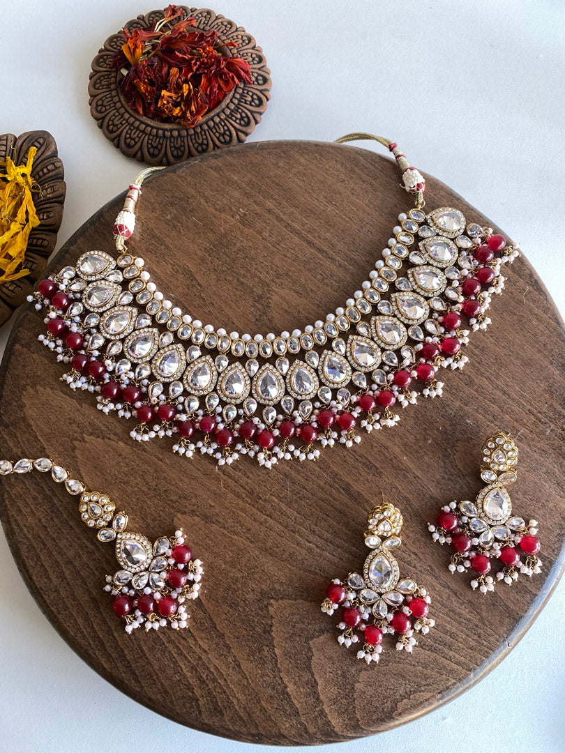Festive Essentials - Our most loved set, Nilu, perfect for modern and traditional look. It has antique gold base with clear white or champagne stones, some pearl work and some colorful stones as you choose. If you want any specific color other than mentioned above, and for any other inquiries please contact us on whatsapp at +1(313)-727-1045.